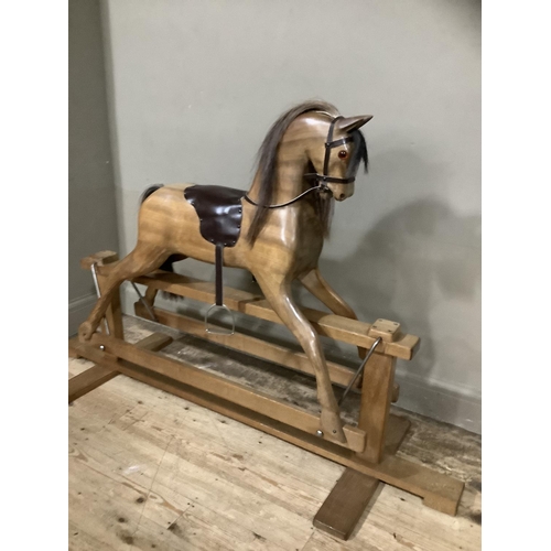 262 - A fruitwood carved rocking horse with leather reigns and saddle with horse hair mane and tail, 163cm... 