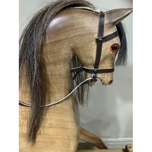 262 - A fruitwood carved rocking horse with leather reigns and saddle with horse hair mane and tail, 163cm... 