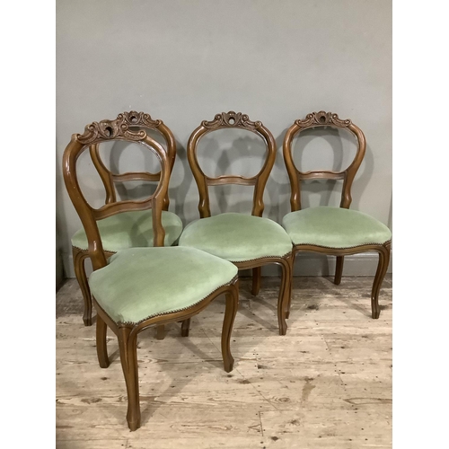 271 - A set of four walnut continental style chairs with heavily carved and pierced back upholstered with ... 