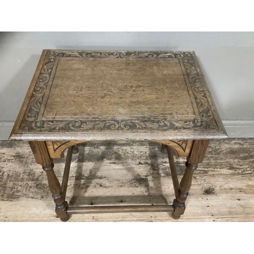 274 - An oak side table, the top carved with oak leaves on turned legs with stretcher