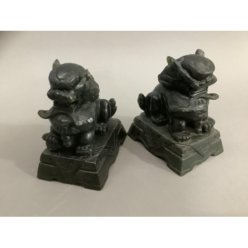 23 - A pair of carved green soapstone temple lions on plinths, 10cm high