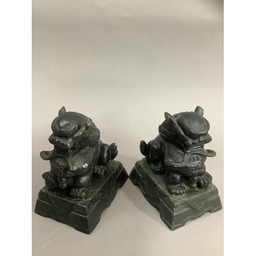 23 - A pair of carved green soapstone temple lions on plinths, 10cm high