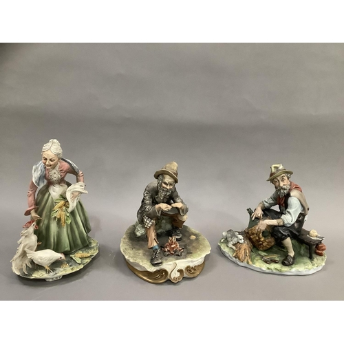 28 - Three Capodimonte figures, a man with a fire and a man on a bench weaving a basket with a dog and a ... 