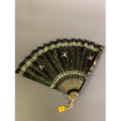 37 - An Art Nouveau fan, the monture of bone, shaped and gilded, the silk leaf painted with a lady in a s... 