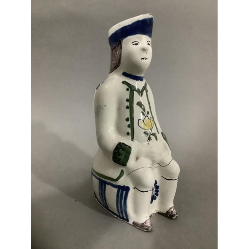 16 - An 18th/19th century Delft toby jug, hand painted formed of a man atop a barrel, 19cm high