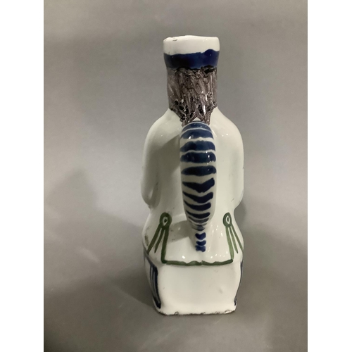 16 - An 18th/19th century Delft toby jug, hand painted formed of a man atop a barrel, 19cm high