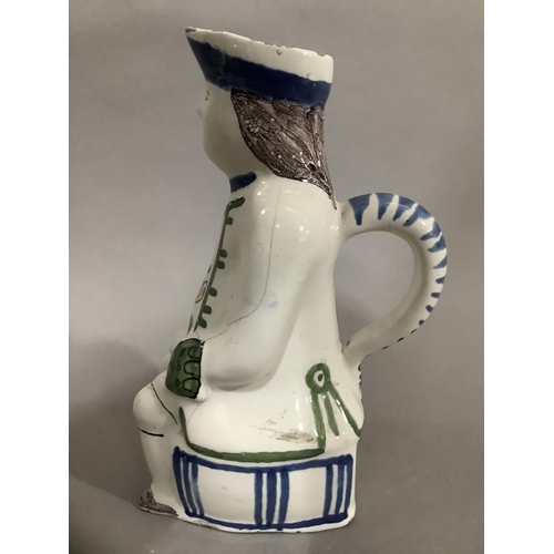 16 - An 18th/19th century Delft toby jug, hand painted formed of a man atop a barrel, 19cm high