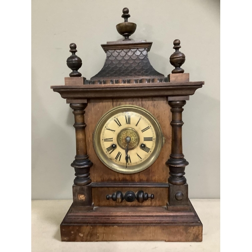 127 - A German heavily carved wooden clock with pitched roof and urn finials, HAC movement, enamel dial wi... 