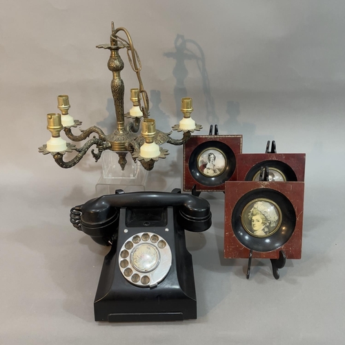 97 - A brass five armed electrolier with ceiling chain and a bakelite telephone and three reproduction po... 