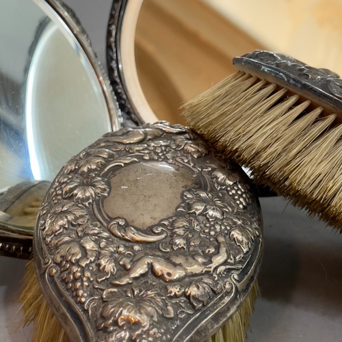 180 - A George V tortoiseshell silver moulded hand mirror, London 1923, together with an Edward VII matche... 