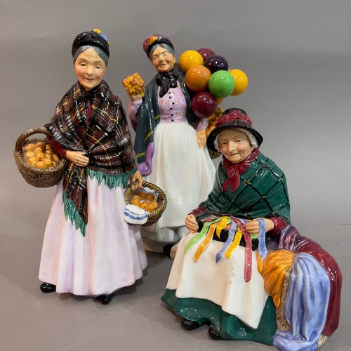 56 - A Royal Doulton 'The Old Balloon Seller' 23cm high, 'The Orange Lady' 22cm high, 'Silks and Ribbons'... 