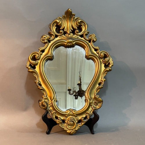 135 - A gilt cast metal shield shaped wall mirror with foliate pierced frame, 47cm