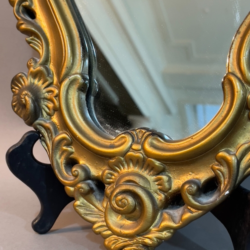 135 - A gilt cast metal shield shaped wall mirror with foliate pierced frame, 47cm