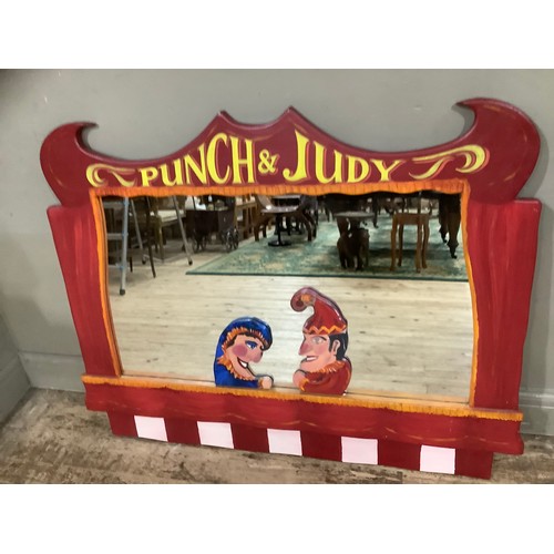 129 - A large wall mirror, the frame formed of Punch and Judy figures to the bottom and 'Punch and Judy' l... 