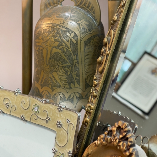 83 - A gilt metal cast table mirror, a brass bell gong, two brass engraved ashtrays, brass tongs