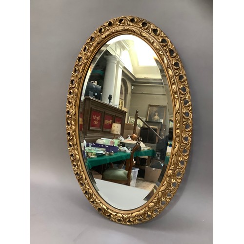 161 - A gilt oval wall mirror with pierced and moulded frame, 78cm high