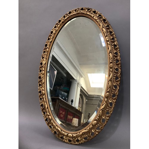 161 - A gilt oval wall mirror with pierced and moulded frame, 78cm high