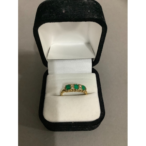 205 - A George V emerald and diamond ring in 18ct gold, the three set cut emeralds claw set in line, inter... 