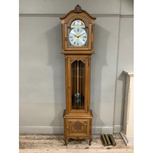 215 - An oak longcase clock of Victorian style with three train movement chiming on rods, the dial with bl... 