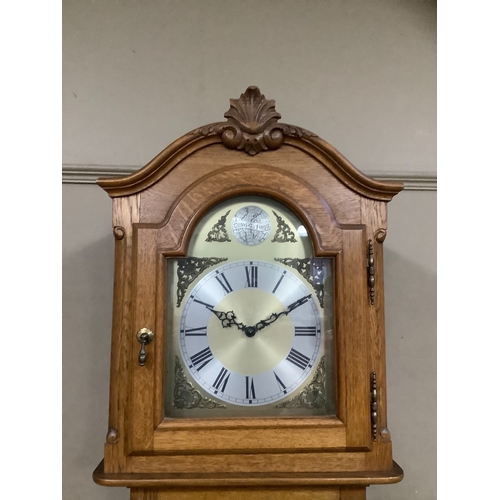 215 - An oak longcase clock of Victorian style with three train movement chiming on rods, the dial with bl... 