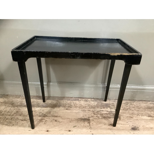 228 - An vintage ebonised bed tray on folding legs, 70cm wide