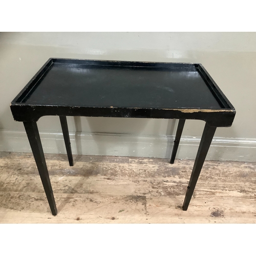 228 - An vintage ebonised bed tray on folding legs, 70cm wide