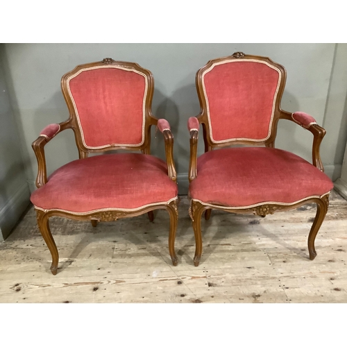 240 - A pair of French style open armchairs having encircling frames with coral upholstery on cabriole leg... 