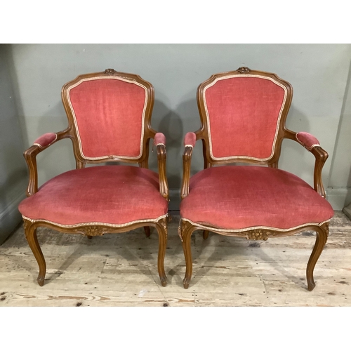 240 - A pair of French style open armchairs having encircling frames with coral upholstery on cabriole leg... 