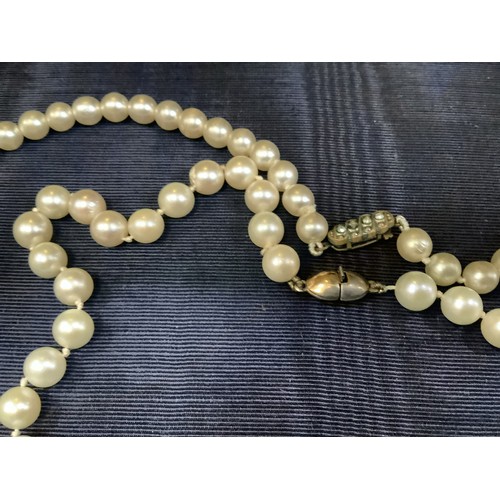 201B - A cultured pearl necklace, the 6.5mm pearls fastened with a base metal strap, approximate length 45c... 