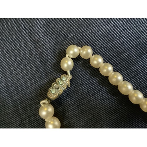 201B - A cultured pearl necklace, the 6.5mm pearls fastened with a base metal strap, approximate length 45c... 