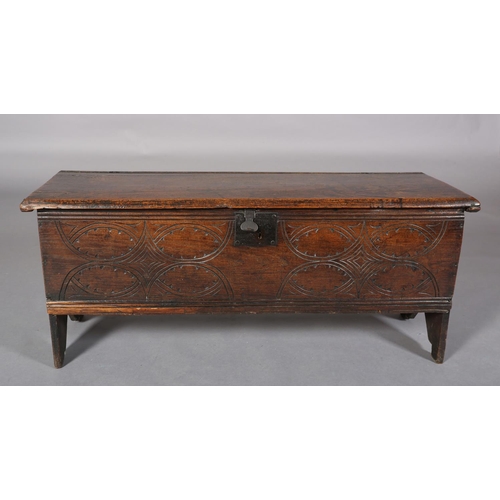 363 - A MID 17TH CENTURY OAK BOARDED CHEST, having a two plank top over the carved front, incised interloc... 