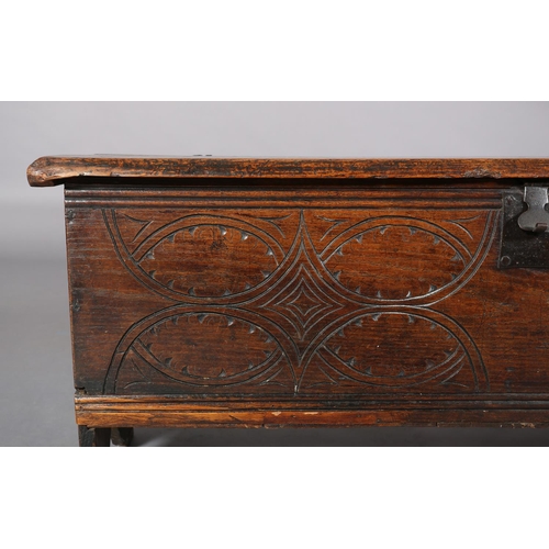 363 - A MID 17TH CENTURY OAK BOARDED CHEST, having a two plank top over the carved front, incised interloc... 