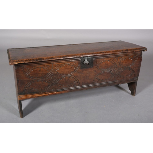 363 - A MID 17TH CENTURY OAK BOARDED CHEST, having a two plank top over the carved front, incised interloc... 