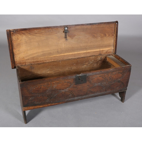 363 - A MID 17TH CENTURY OAK BOARDED CHEST, having a two plank top over the carved front, incised interloc... 