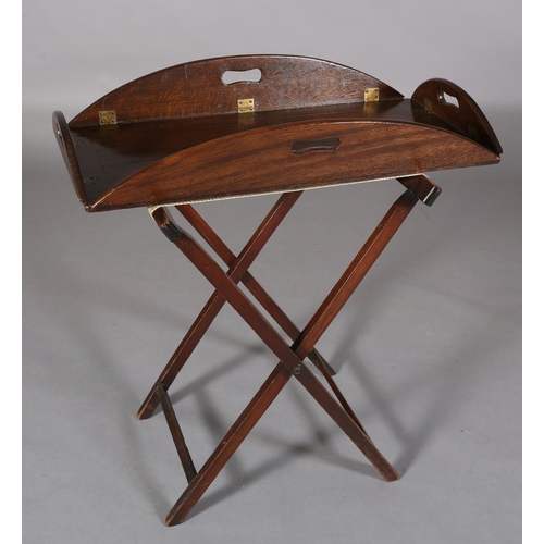 366 - AN OAK AND BRASS BUTLER'S TRAY, oval hinged sides with finger grips, on a folding stand, c.1920s, 81... 