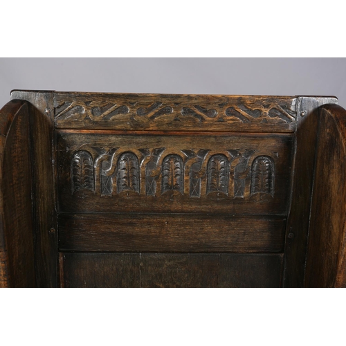 367 - AN 18TH CENTURY STYLE OAK WINGED CHAIR, the back carved with a panel of interlocking foliate filled ... 