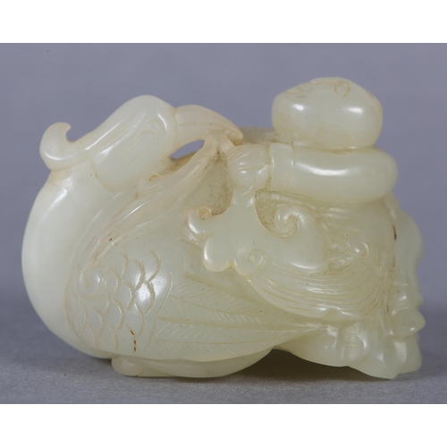 116 - A CHINESE JADE CARVING OF A BOY CLIMBING UPON THE BACK OF A PHOENIX with its head turned backwards h... 