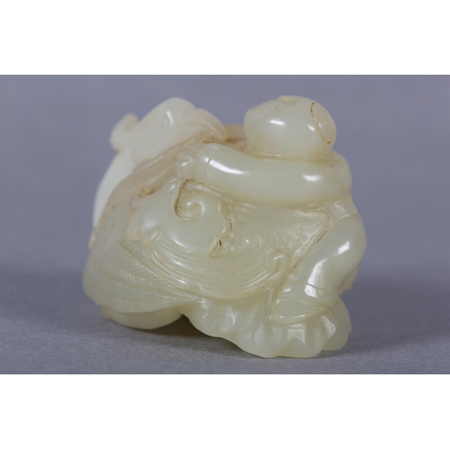 116 - A CHINESE JADE CARVING OF A BOY CLIMBING UPON THE BACK OF A PHOENIX with its head turned backwards h... 