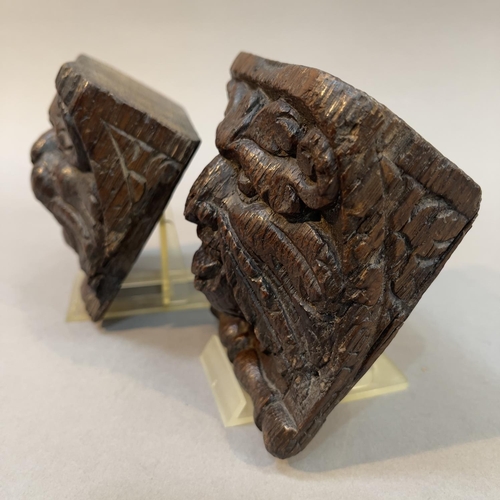 66 - A PAIR OF 18TH CENTURY OAK ANGLE BRACKETS CARVED AS A LION FACE MASK AND GREEN MAN FACE MASK, each w... 