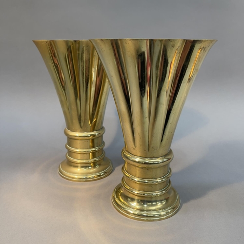 58 - A PAIR OF 19TH CENTURY BRASS VASES OF FLATTENED FLUTED FORM ON AN ANNULATED CIRCULAR BASE AND FOOT, ... 