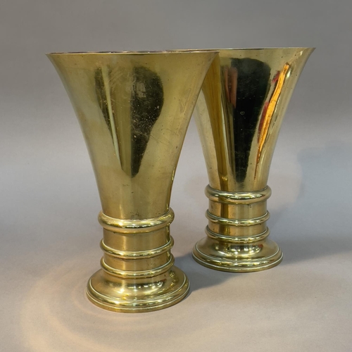 58 - A PAIR OF 19TH CENTURY BRASS VASES OF FLATTENED FLUTED FORM ON AN ANNULATED CIRCULAR BASE AND FOOT, ... 