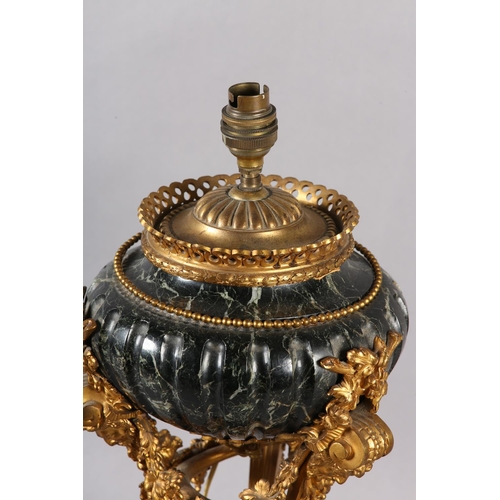 43 - A FRENCH DARK GREEN MARBLE AND GILT METAL TABLE LAMP, raised on three legs with bearded face mask pa... 