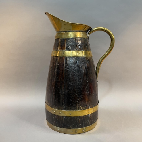 28 - AN EARLY 20TH CENTURY OAK AND BRASS BOUND COOPERED JUG, 55.5cm high (Shipping category E)