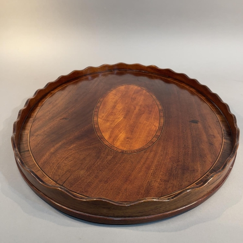 75 - AN EARLY 19TH CENTURY MAHOGANY AND ROSEWOOD CROSSBANDED OVAL TRAY, with wavy gallery, oval panel to ... 