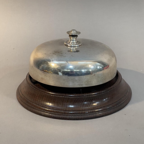 30 - AN EARLY 20TH CENTURY SILVER PLATED AND OAK COUNTER BELL, 13cm high x 21.5cm diameter (Shipping cate... 