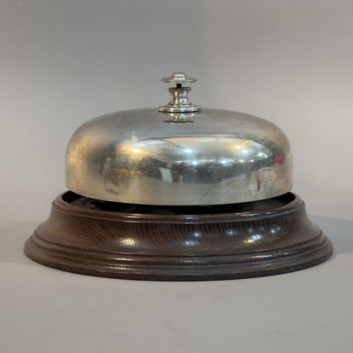 30 - AN EARLY 20TH CENTURY SILVER PLATED AND OAK COUNTER BELL, 13cm high x 21.5cm diameter (Shipping cate... 