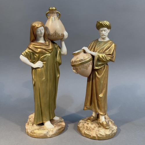 88 - A PAIR OF ROYAL WORCESTER ARAB WATER CARRIERS, blush ivory enriched in gilt, the male and female fig... 