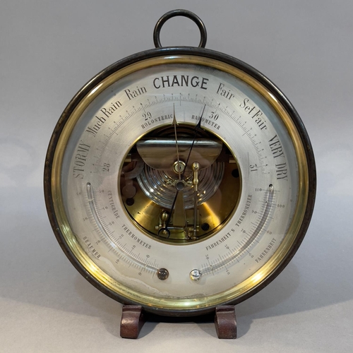 29 - AN EARLY 20TH CENTURY ANEROID BAROMETER-THERMOMETER in lacquered brass case with pendant loop, 20.5c... 