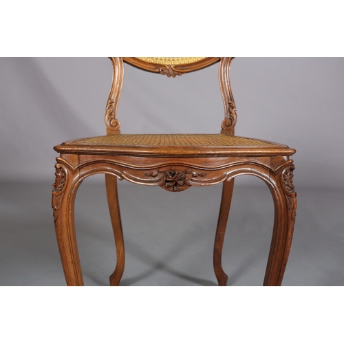 395 - A VICTORIAN WALNUT AND GILDED BERGERE CANED SALON CHAIR, having an oval back with moulded encircling... 