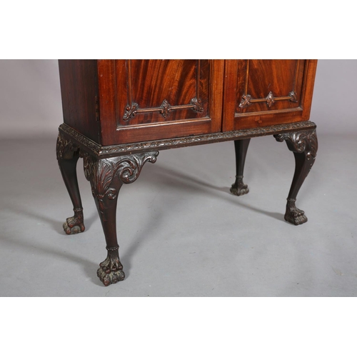 383 - A MAHOGANY CABINET, c1900, having a gadroon rim above two drawers with applied foliate scroll work a... 